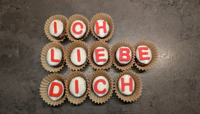 Plätzchen mit Buchstaben aus Zuckergussschrift zusammengelegt zu dem Satz "Ich liebe dich"